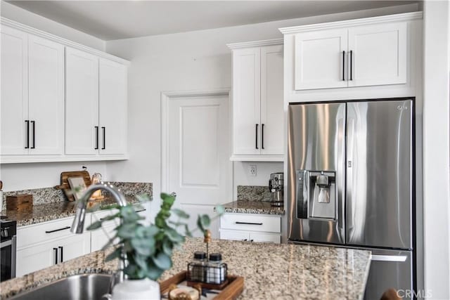 30219 Old Mill Rd, Menifee, CA 92584 - kitchen featuring stainless steel fridge with ice dispenser, white cabinetry, a sink, and light stone countertops