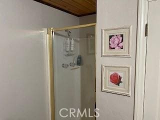 bathroom featuring wood ceiling and a shower with door