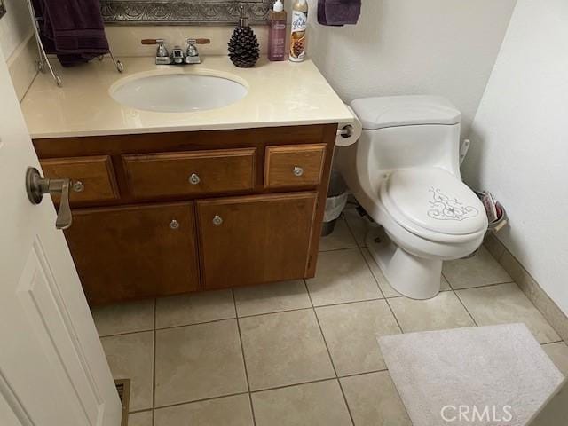 bathroom featuring tile patterned flooring, vanity, and toilet