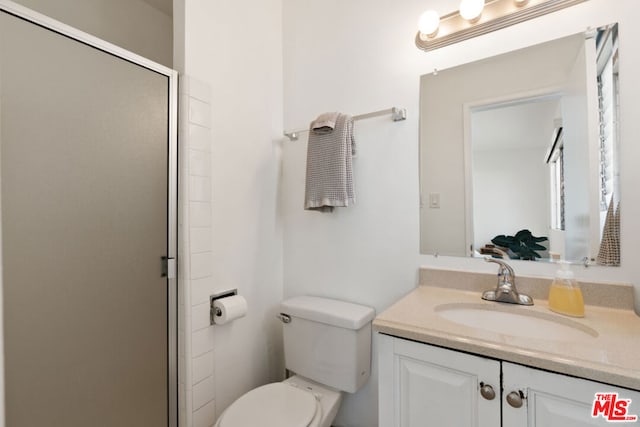 bathroom with an enclosed shower, vanity, and toilet