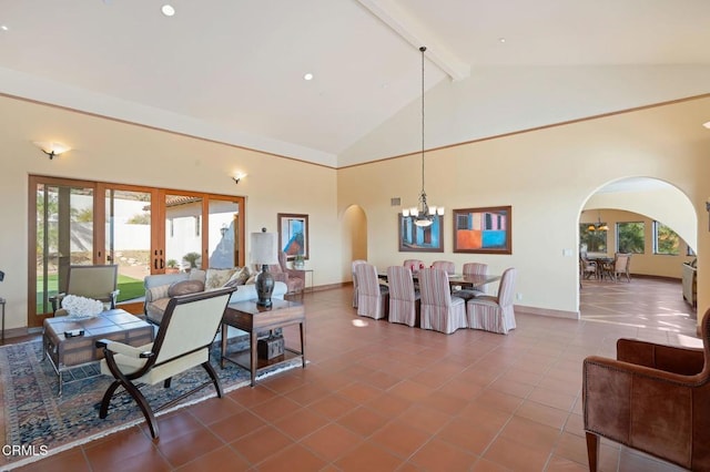 tiled living room featuring arched walkways, a chandelier, and a healthy amount of sunlight