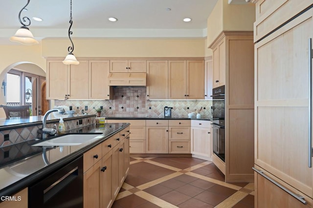 kitchen with a sink, custom exhaust hood, light brown cabinetry, black appliances, and backsplash
