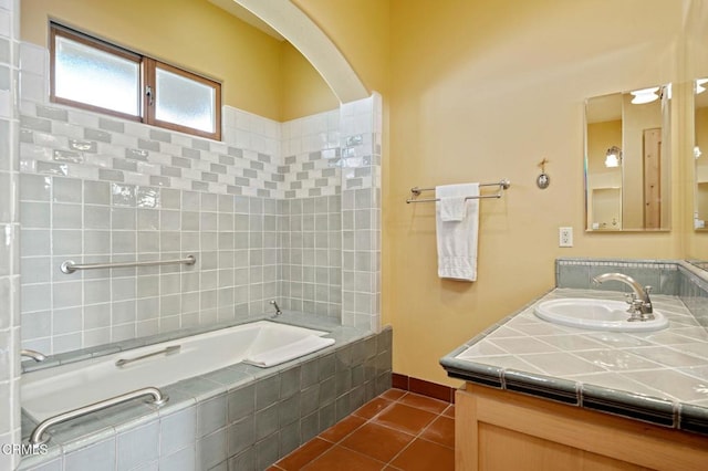 bathroom featuring tile patterned flooring, tiled shower / bath combo, and vanity