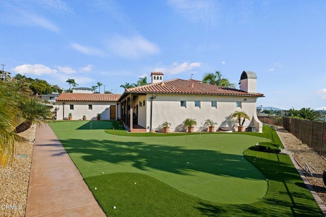back of house with a tile roof, a fenced backyard, and stucco siding