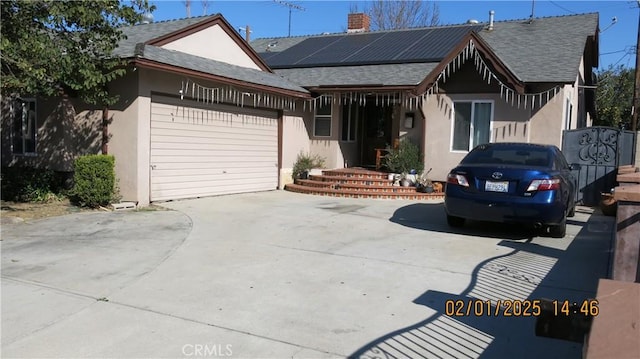 view of front of property featuring a garage and solar panels