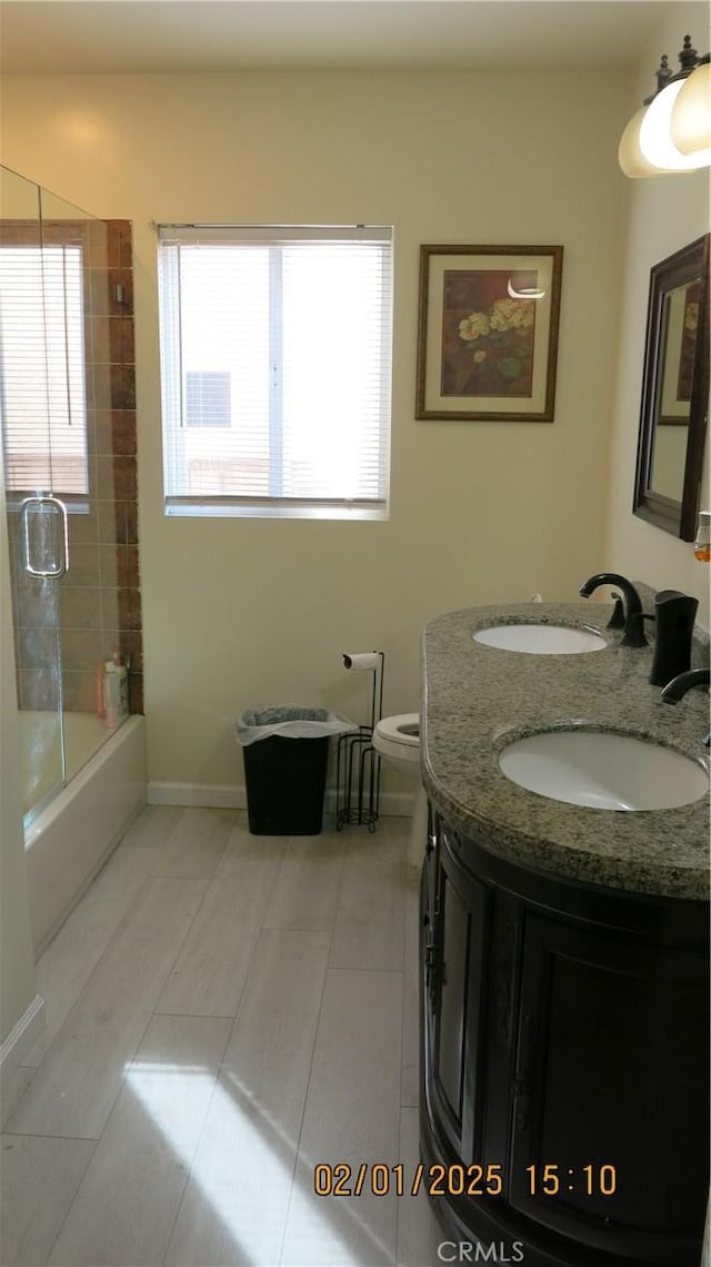 full bathroom featuring shower / bath combination with glass door, vanity, and toilet