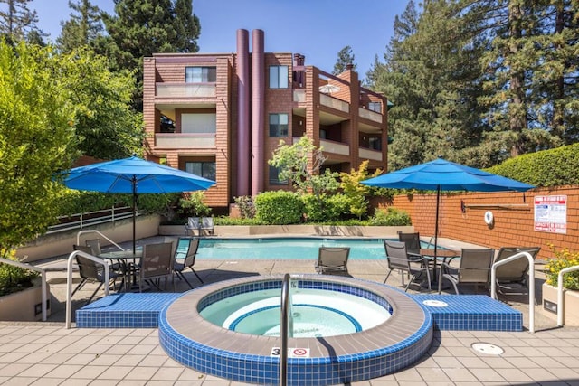 view of pool with a hot tub