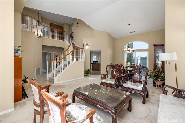 living room with light carpet, high vaulted ceiling, and a chandelier