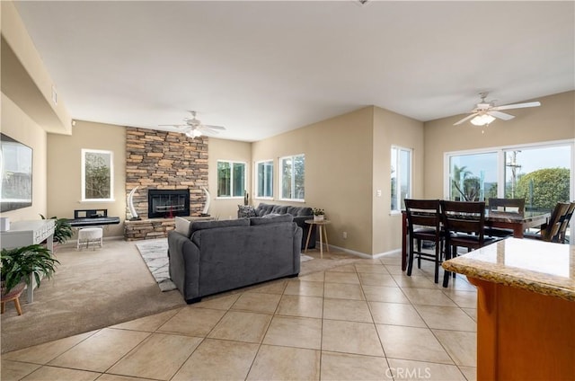 tiled living room featuring ceiling fan, a wealth of natural light, and a fireplace