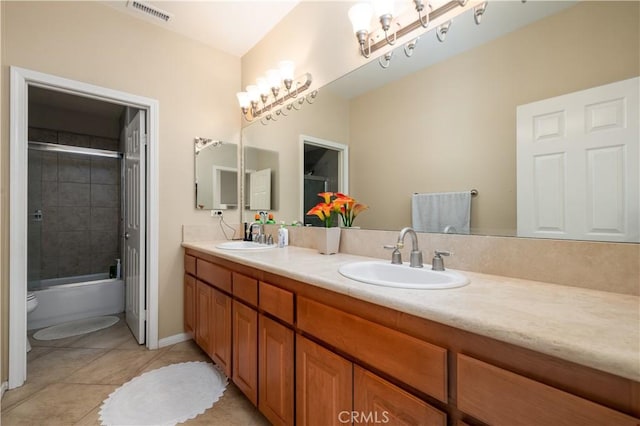 full bathroom featuring vanity, bath / shower combo with glass door, tile patterned floors, and toilet