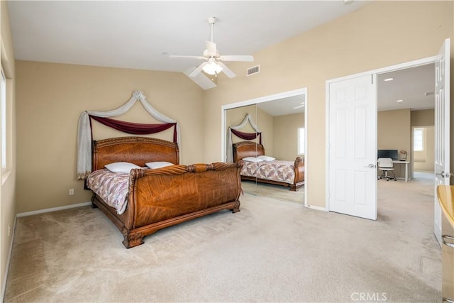 bedroom with vaulted ceiling, light colored carpet, a closet, and ceiling fan