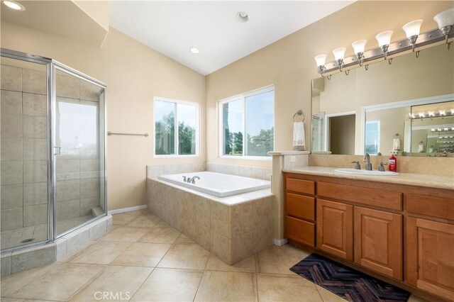 bathroom with tile patterned flooring, vanity, vaulted ceiling, and independent shower and bath