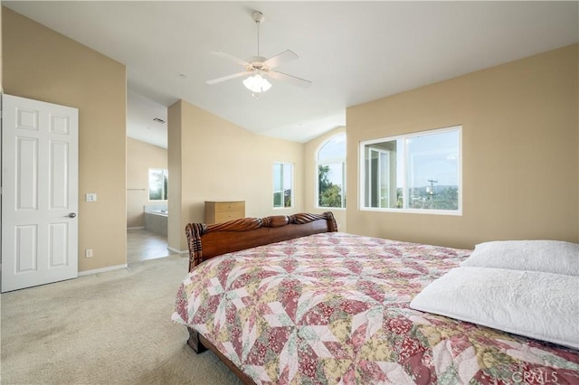 bedroom featuring lofted ceiling, light carpet, connected bathroom, and ceiling fan