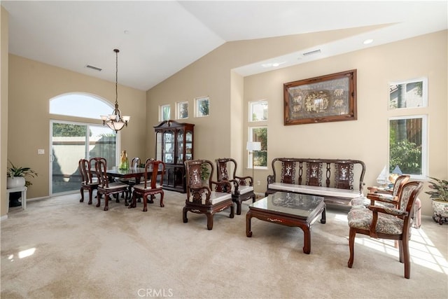 living area featuring high vaulted ceiling, light carpet, and a chandelier