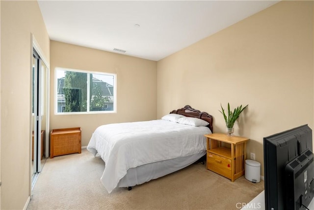 bedroom featuring light carpet and a closet