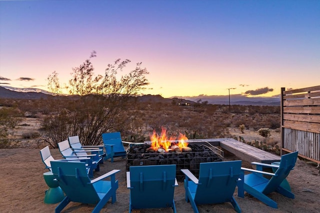 patio terrace at dusk with a mountain view and an outdoor fire pit