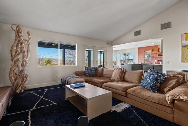 living room with high vaulted ceiling and french doors