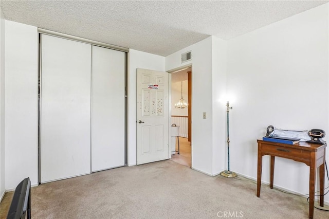 bedroom featuring a closet, a textured ceiling, visible vents, and carpet flooring