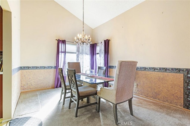 dining room featuring high vaulted ceiling, a wainscoted wall, a notable chandelier, and carpet floors