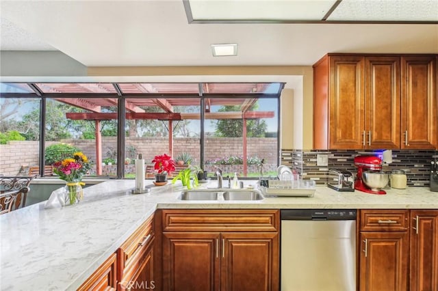 kitchen featuring tasteful backsplash, brown cabinetry, dishwasher, and a sink