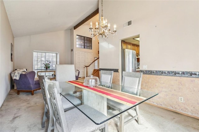 dining room with visible vents, light colored carpet, beamed ceiling, high vaulted ceiling, and a notable chandelier