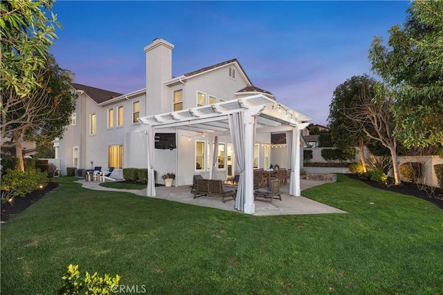 back house at dusk featuring a patio, a yard, and a pergola