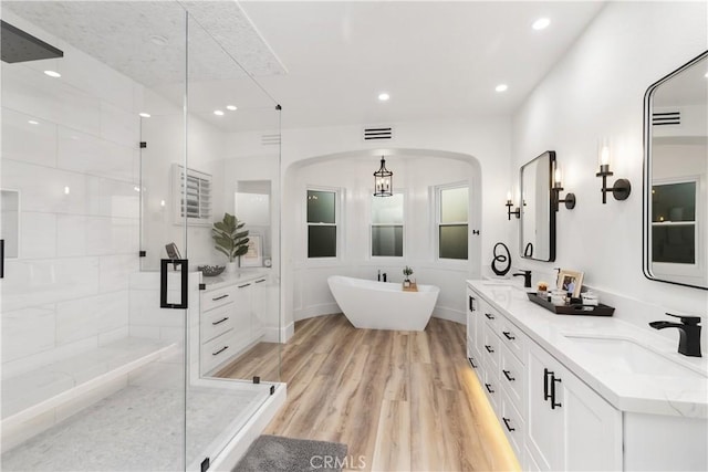 bathroom with independent shower and bath, vanity, and hardwood / wood-style flooring