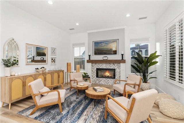 living area featuring a tile fireplace and light hardwood / wood-style flooring