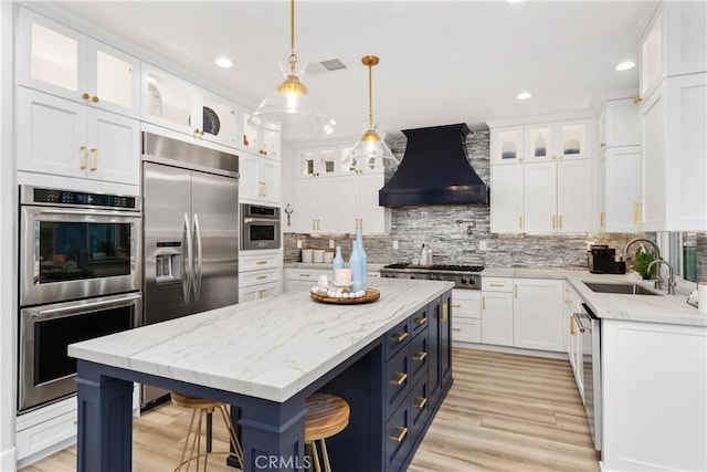 kitchen with white cabinetry, a center island, sink, and custom exhaust hood