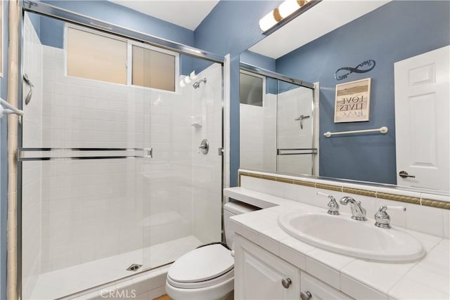 bathroom featuring vanity, toilet, and an enclosed shower