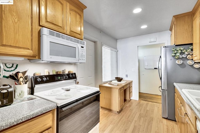 kitchen with black electric range oven, stainless steel fridge, and light wood-type flooring