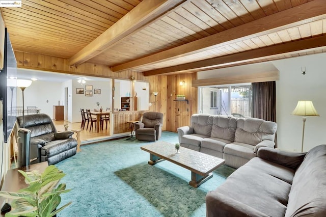 living room featuring wood walls, carpet flooring, beam ceiling, and wooden ceiling