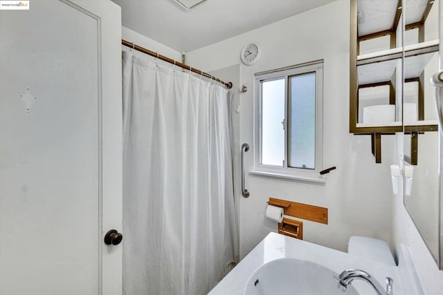 bathroom featuring walk in shower and sink