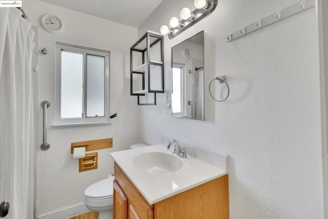 bathroom with vanity, a wealth of natural light, toilet, and a shower with shower curtain