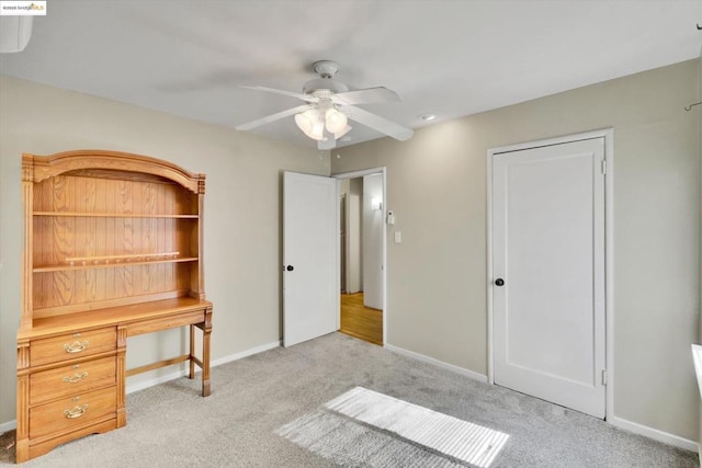 interior space with ceiling fan and light colored carpet