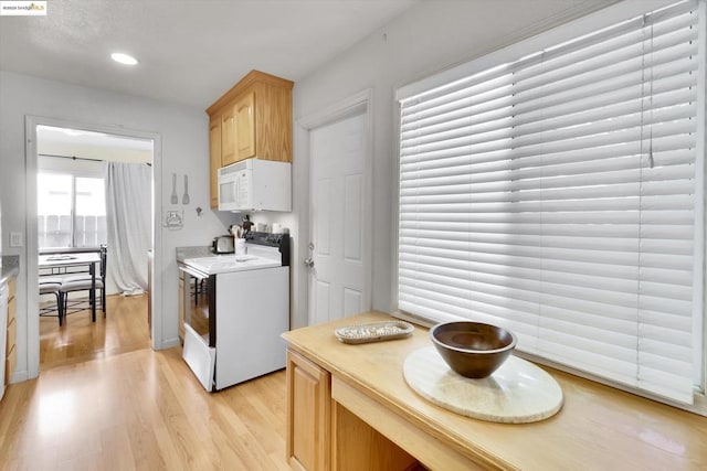 kitchen with white appliances, light brown cabinetry, and light hardwood / wood-style flooring