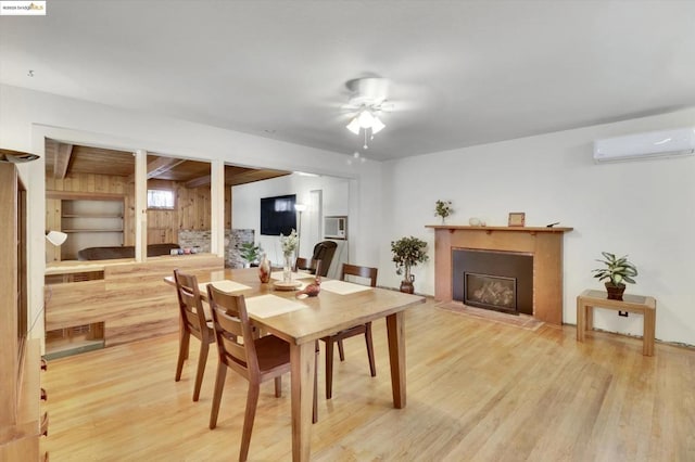 dining area with beamed ceiling, light wood-type flooring, and an AC wall unit