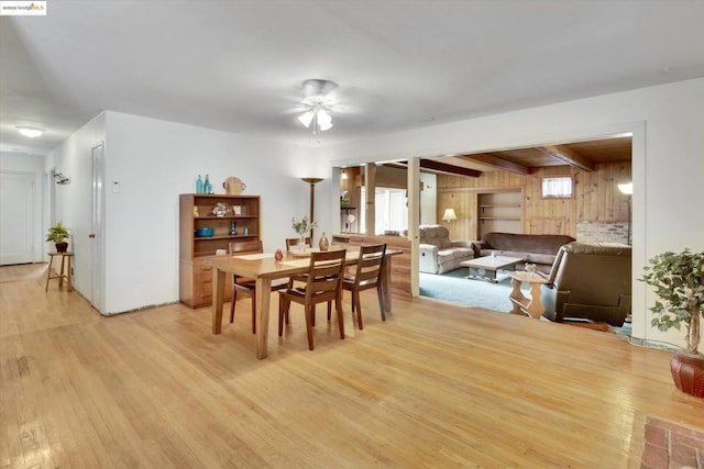 dining space featuring beamed ceiling, ceiling fan, and light hardwood / wood-style floors