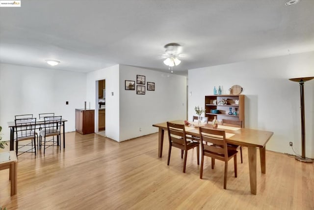 dining area with ceiling fan and light wood-type flooring