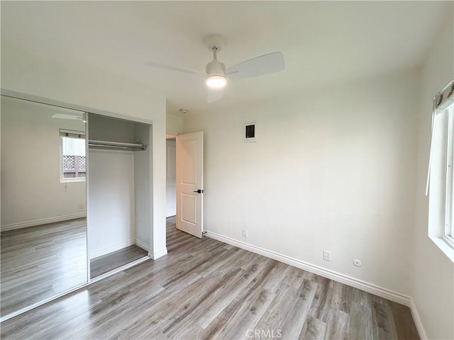 unfurnished bedroom with light wood-type flooring, a closet, and ceiling fan