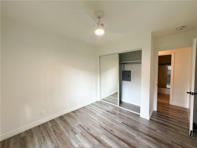 unfurnished bedroom featuring ceiling fan, a closet, and hardwood / wood-style floors