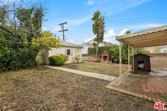 view of yard with an outbuilding and an outdoor fireplace