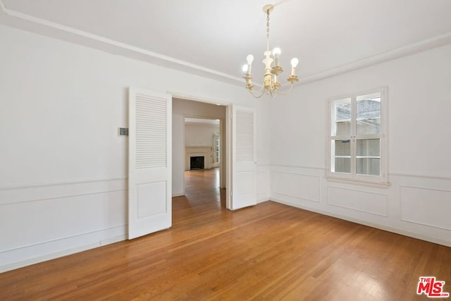 spare room with a chandelier and hardwood / wood-style floors