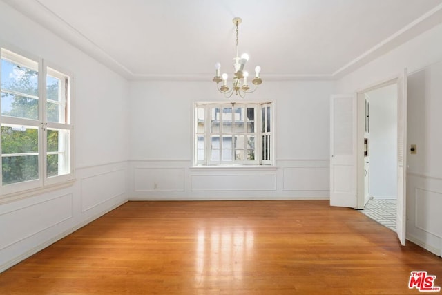 unfurnished dining area with hardwood / wood-style flooring and an inviting chandelier