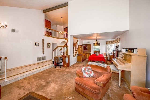 carpeted living room featuring stairs, a high ceiling, visible vents, and a notable chandelier