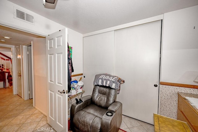 living area featuring light tile patterned floors and visible vents