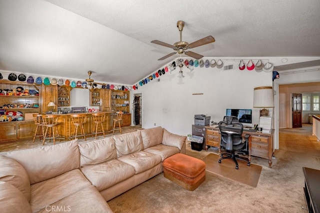 living room featuring light carpet, visible vents, a ceiling fan, lofted ceiling, and a bar