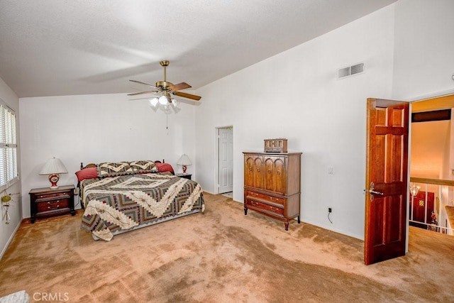 carpeted bedroom with visible vents, vaulted ceiling, and a ceiling fan