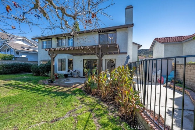 back of house featuring a patio, a chimney, stucco siding, fence, and a pergola