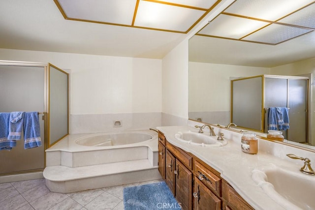 bathroom featuring a bath, double vanity, a sink, and tile patterned floors